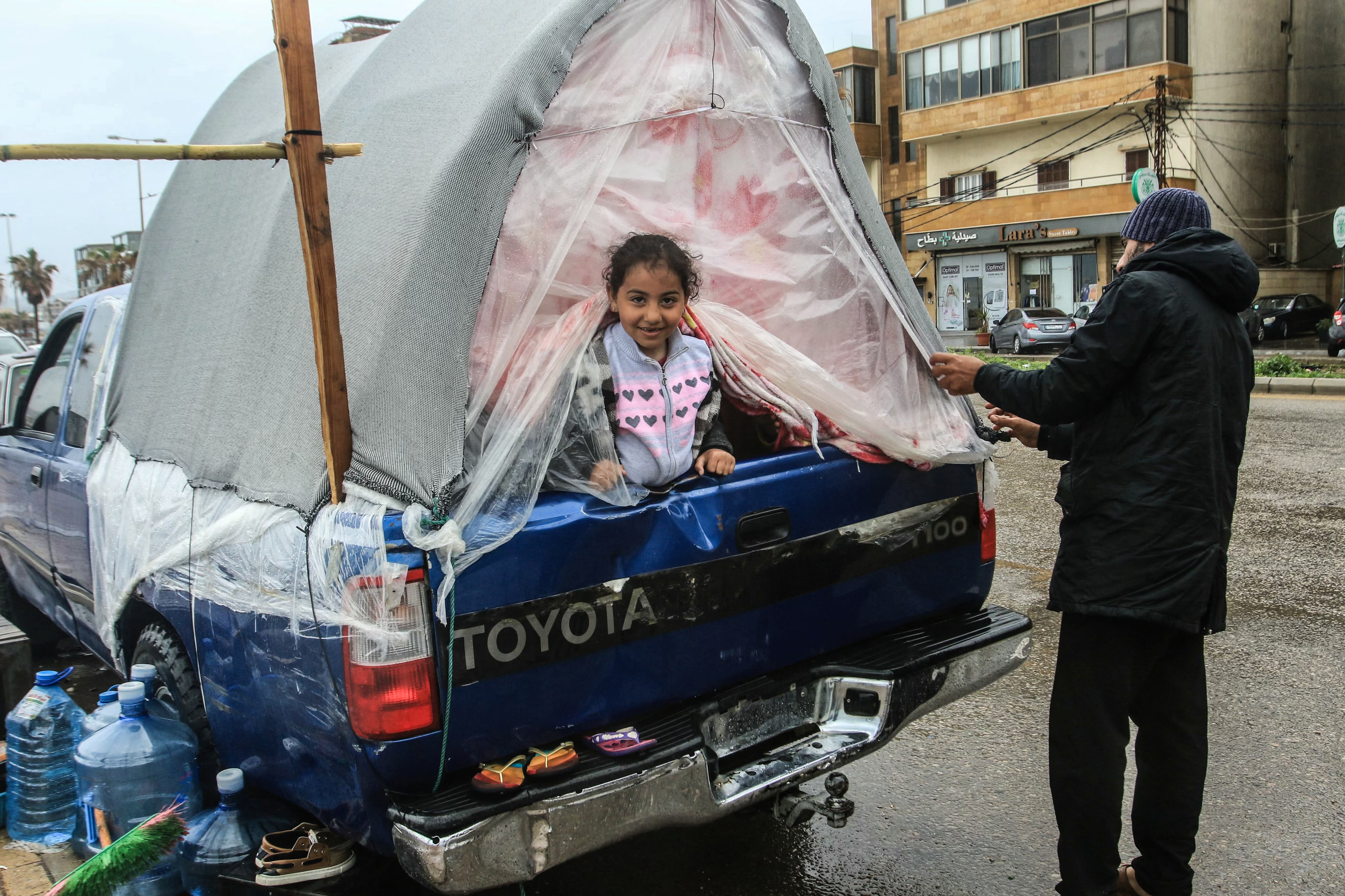 A displaced girl sits in the back of a pick-up truck in Lebanon’s southern city of Sidon on March 15. Lebanon is working to form a delegation to negotiate with Israel in a bid to stop the war with Hezbollah.  (photo credit: MAHMOUD ZAYYAT/AFP via Getty Images)