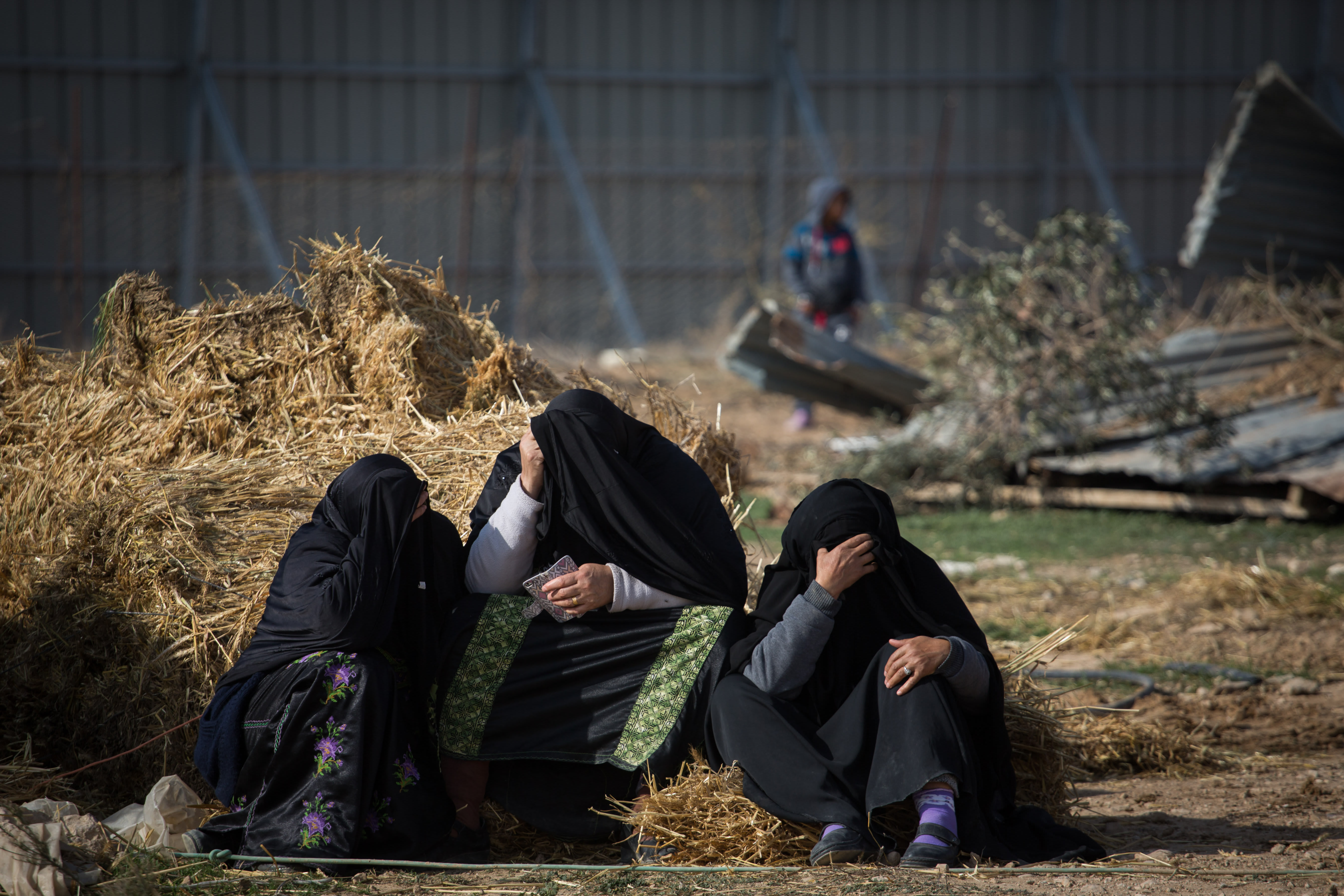Bedouin women sit outside their demolished homes in the Bedouin village of Umm al-Hiran in the Negev desert, in the in the Southern Israel, January 18, 2017.  (photo credit: HADAS PARUSH/FLASH90)