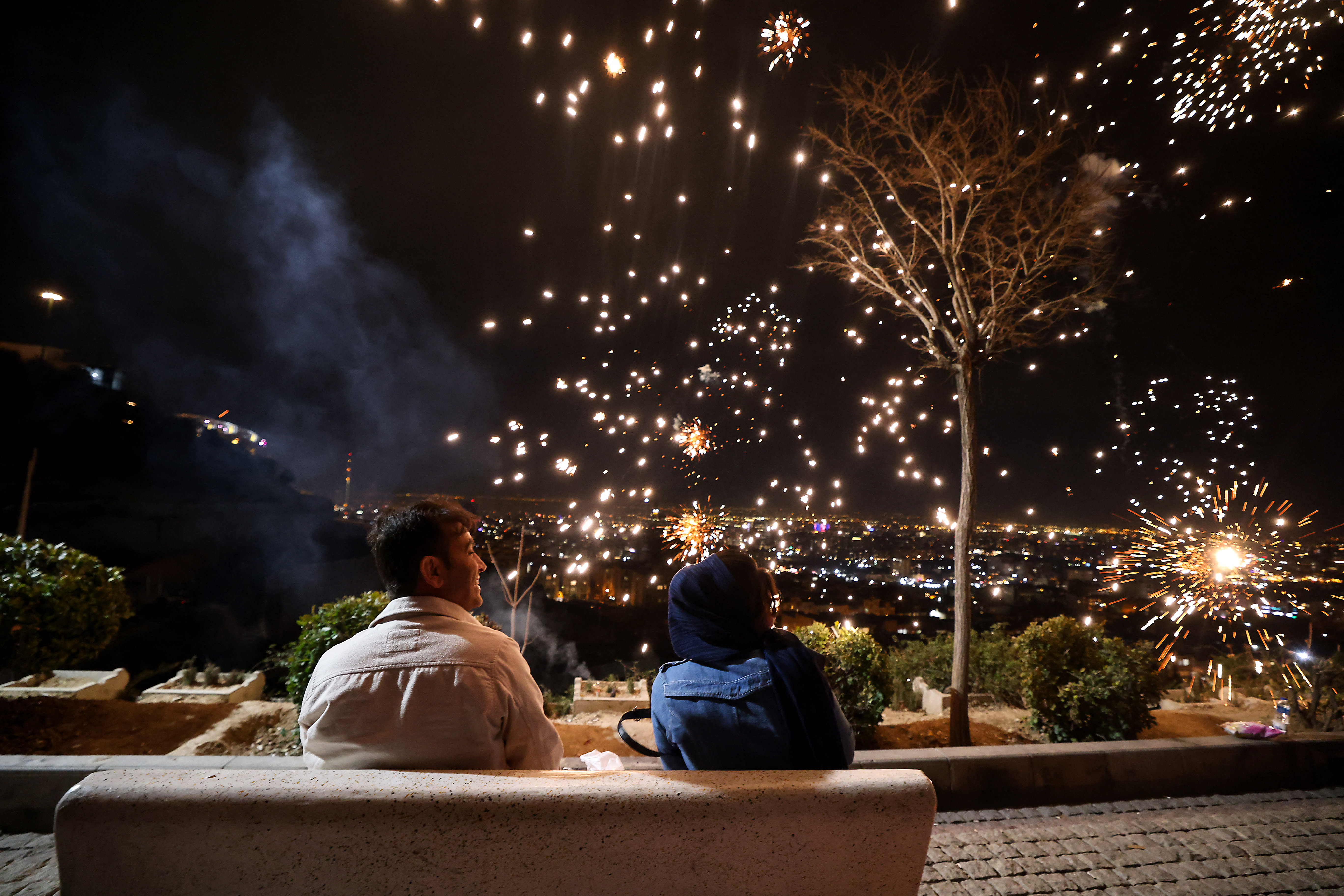 Iranians watch fireworks during the Wednesday Fire feast, or Chaharshanbe Suri, held annually on the last Wednesday eve before the Spring holiday of Nowruz, in Tehran, on March 18, 2025.  (photo credit: ATTA KENARE / AFP) (Photo by ATTA KENARE/AFP via Getty Images)