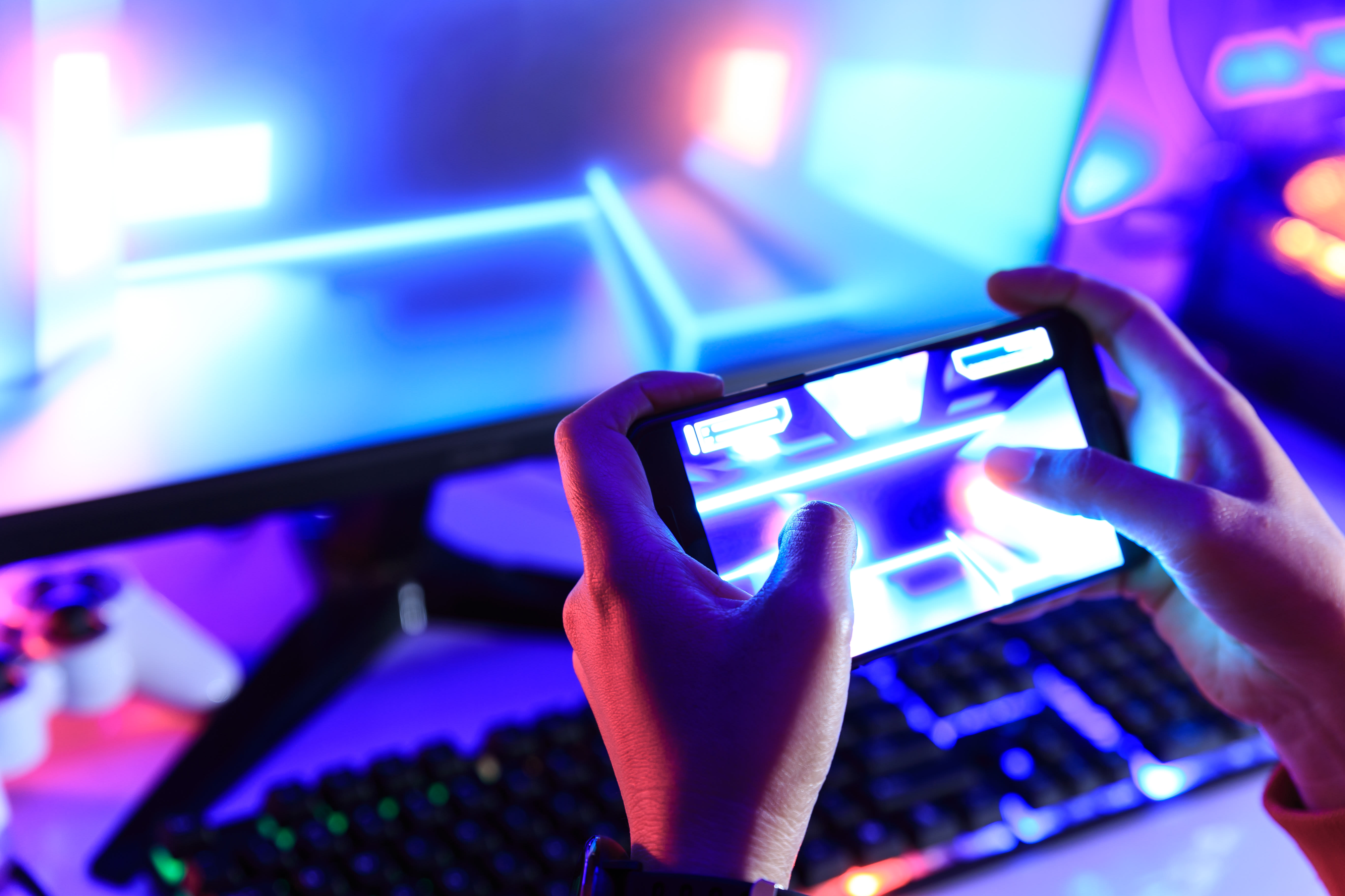 Gamer playing online game via smart phone in dark room (photo credit: SHUTTERSTOCK)