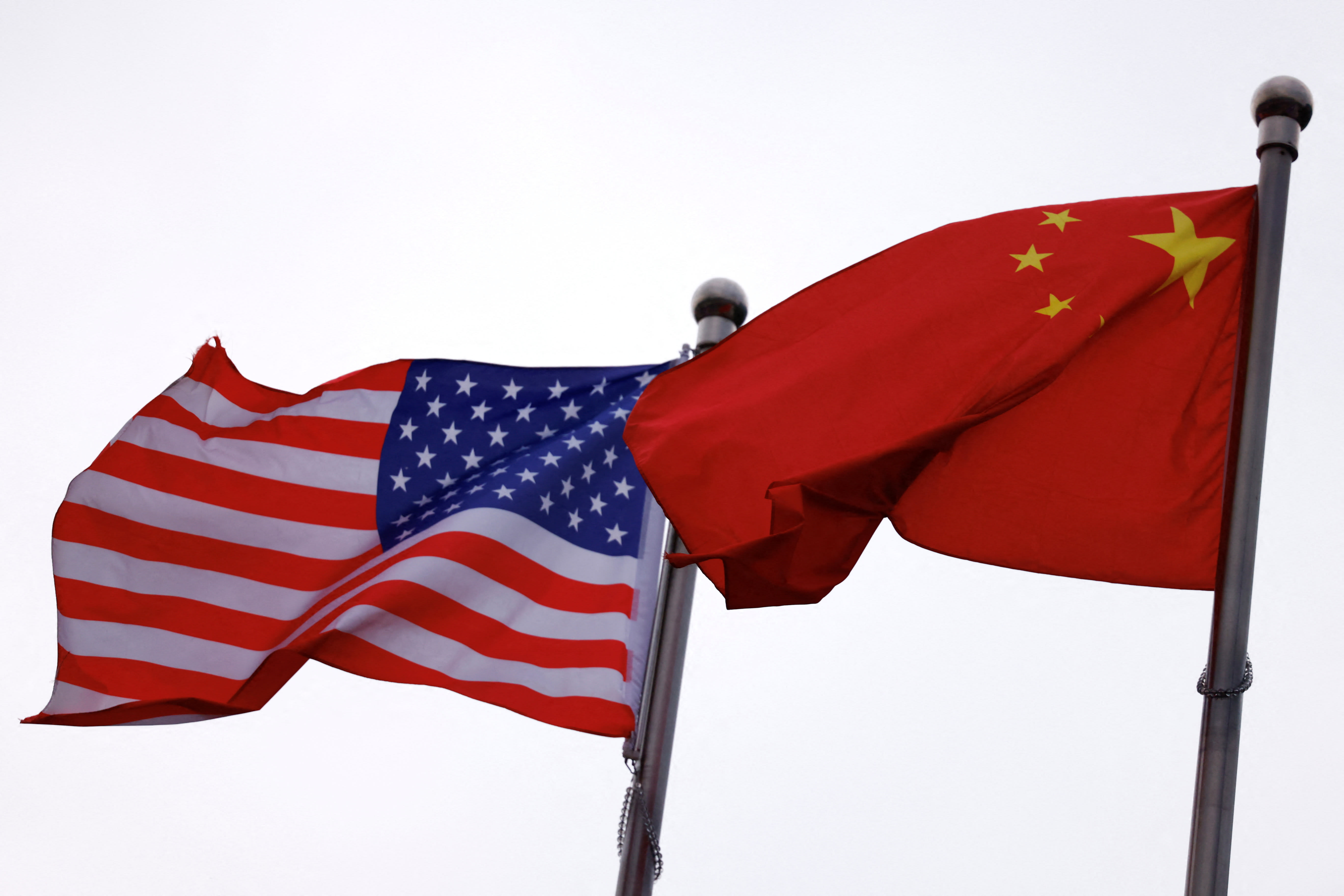 Chinese and US flags flutter outside the building of an American company in Beijing, April 8, 2025. (photo credit: REUTERS/TINGSHU WANG)