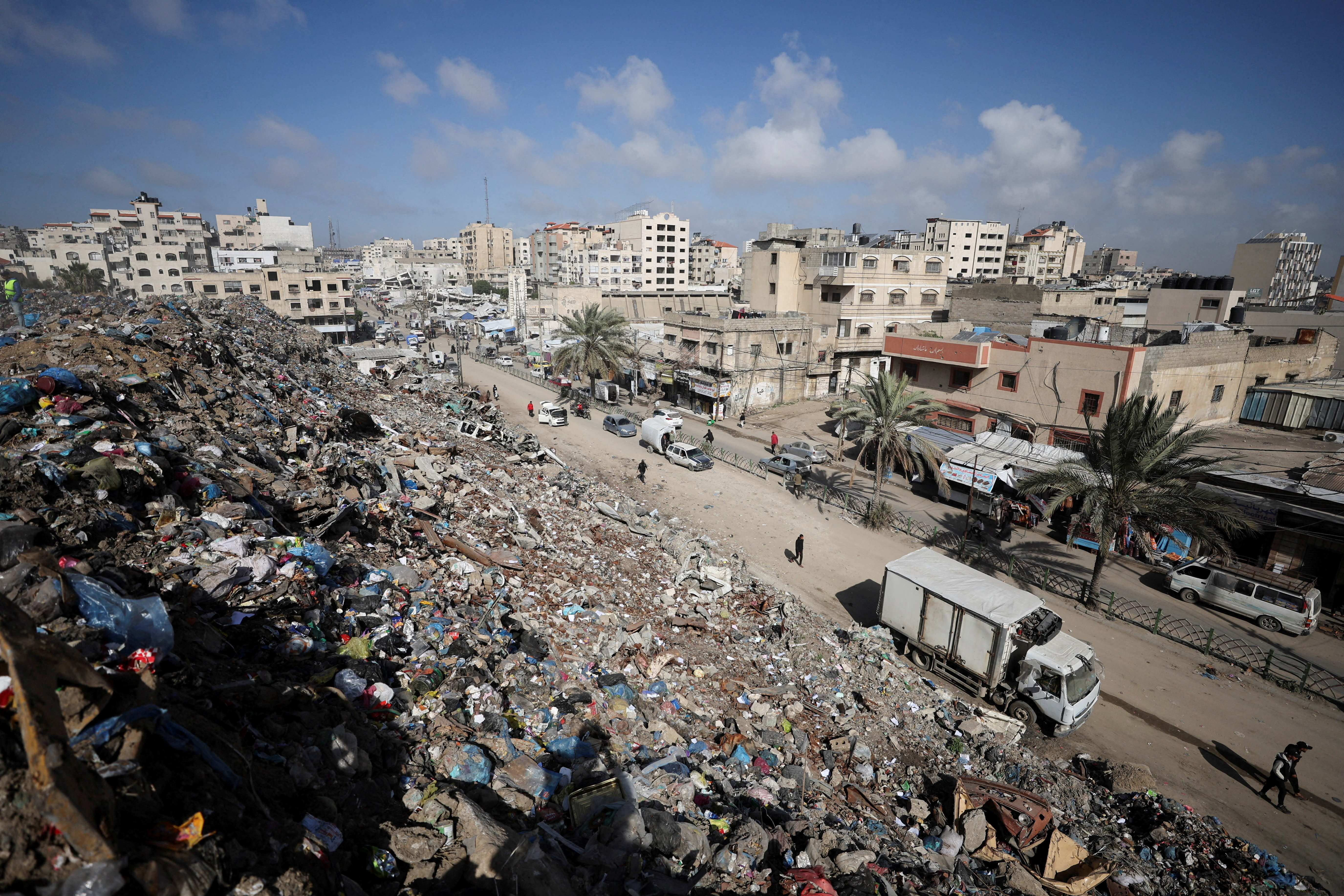 PALESTINIANS WALK near a landfill, in Gaza City, February 11, 2026. (photo credit: REUTERS/Dawoud Abu Alkas TPX IMAGES OF THE DAY)