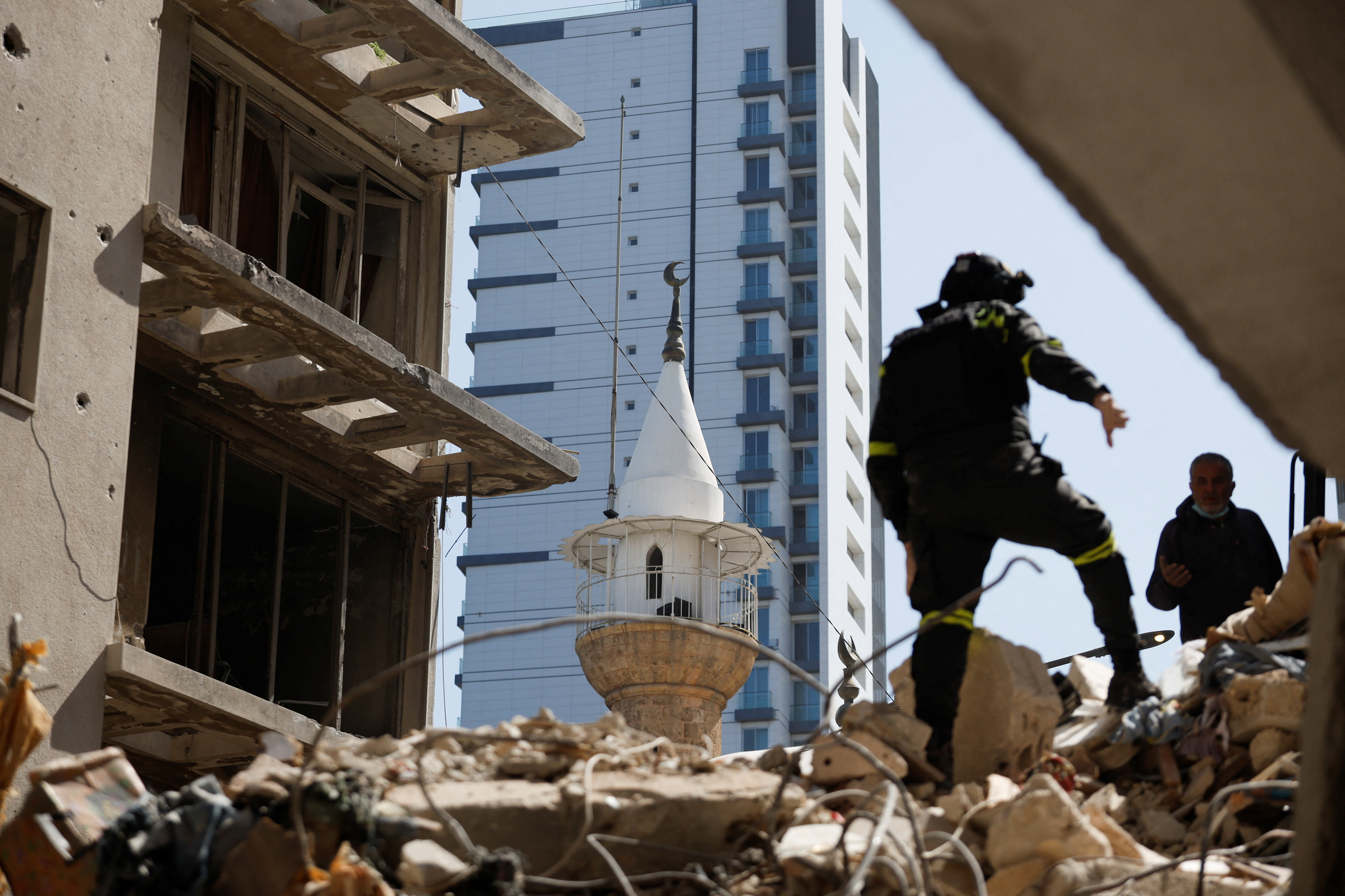 A man stands on the rubble as emergency services operate at the site of an Israeli strike carried out on Wednesday, in Ain Al Mraiseh in Beirut, Lebanon, April 9, 2026 (photo credit: REUTERS/Louisa Gouliamaki)