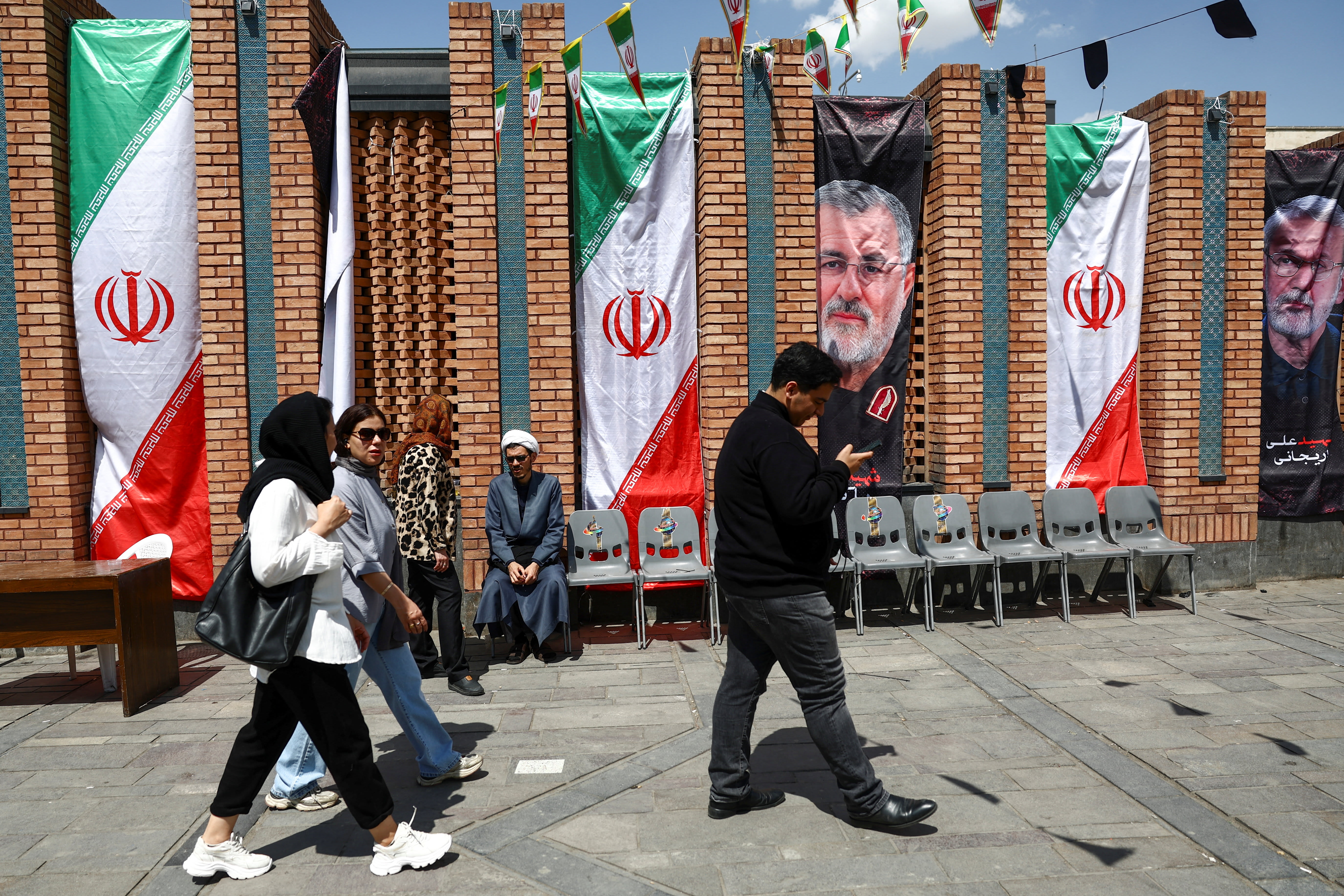 People walk past a banner with a picture of the late Islamic Revolutionary Guard Corps (IRGC) commander Mohammad Pakpour, in Tehran Bazaar, Iran, April 21, 2026 (photo credit: MAJID ASGARIPOUR/WANA (WEST ASIA NEWS AGENCY) VIA REUTERS)