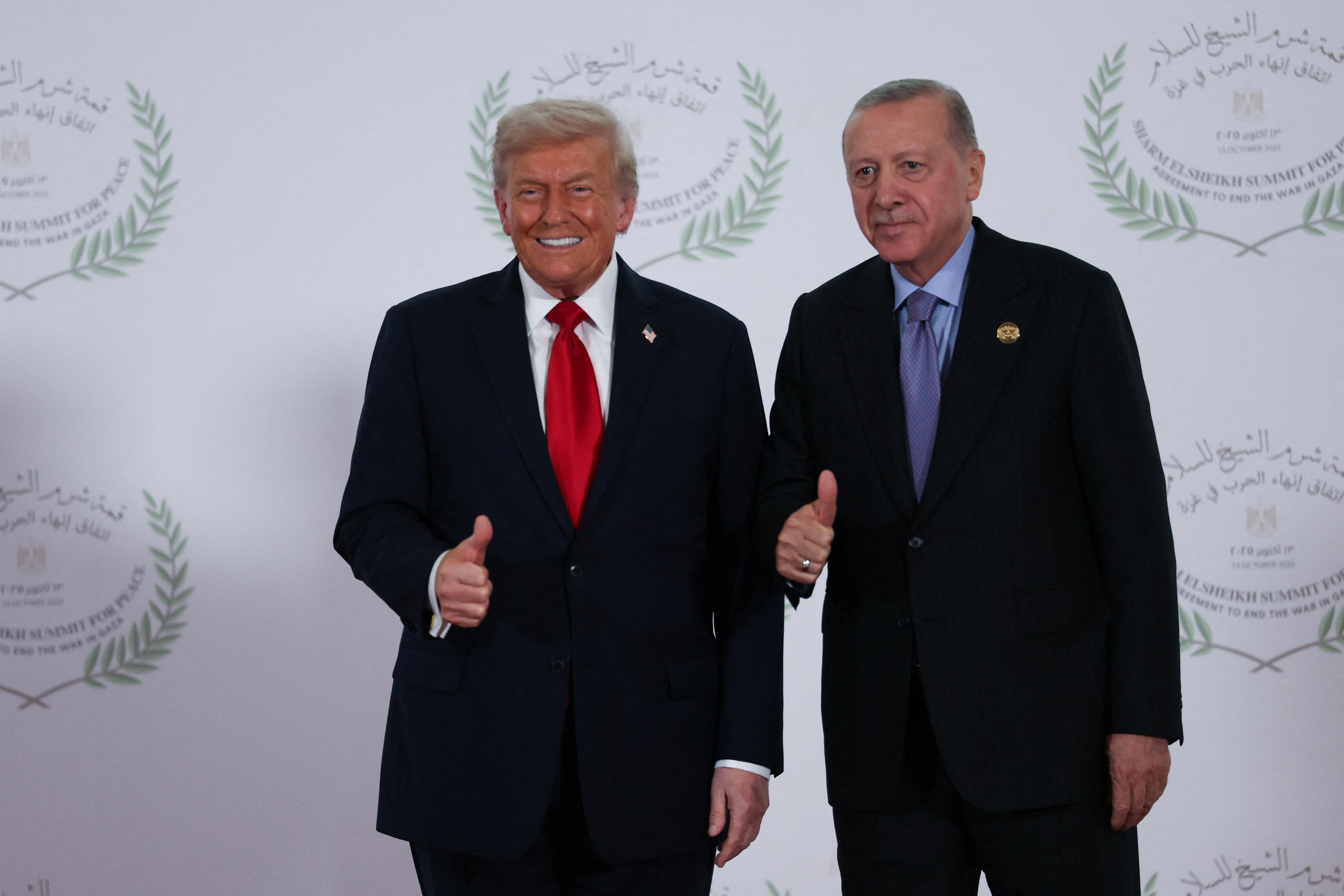 US President Donald Trump and Turkish President Tayyip Erdogan gesture as they pose for a photo, at a world leaders
