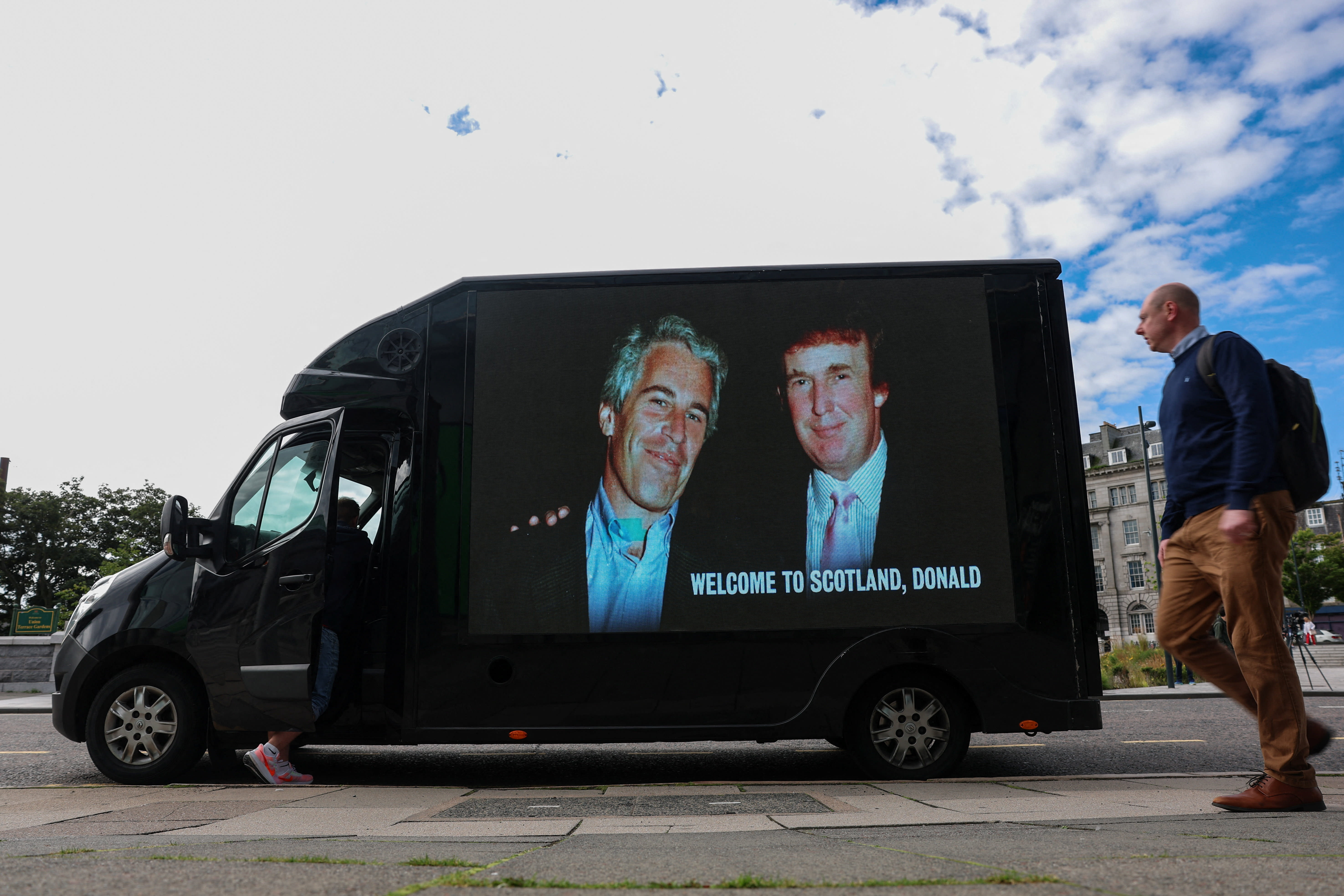 A person walks next to a mobile Ad Van that displays a photograph of U.S. President Donald Trump and disgraced financier and sex offender Jeffrey Epstein, in protest of the visit of U.S. President Donald Trump in Aberdeen, Scotland, Britain, July 28, 2025.  (photo credit: REUTERS/HANNAH MCKAY)