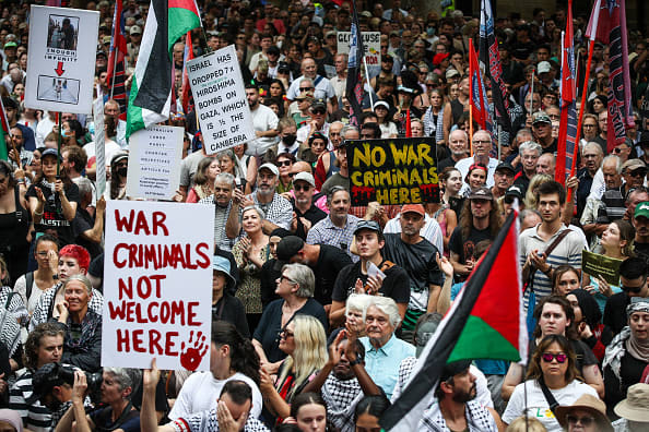  People hold up placards during a protest against the visit of Israel