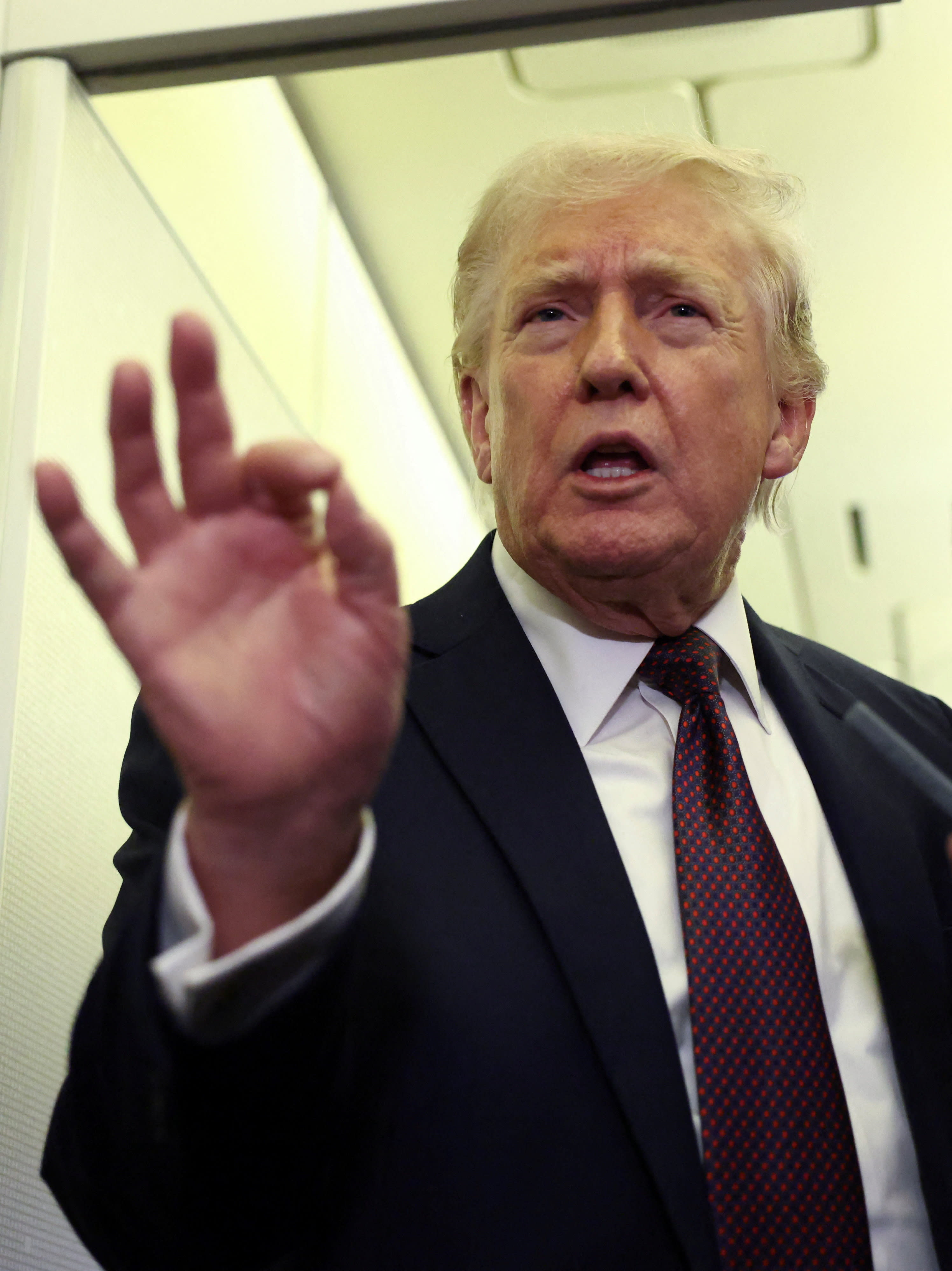US President Donald Trump speaks to reporters aboard Air Force One on a flight back to Washington, March 15, 2026. (photo credit: REUTERS/KEVIN LAMARQUE)