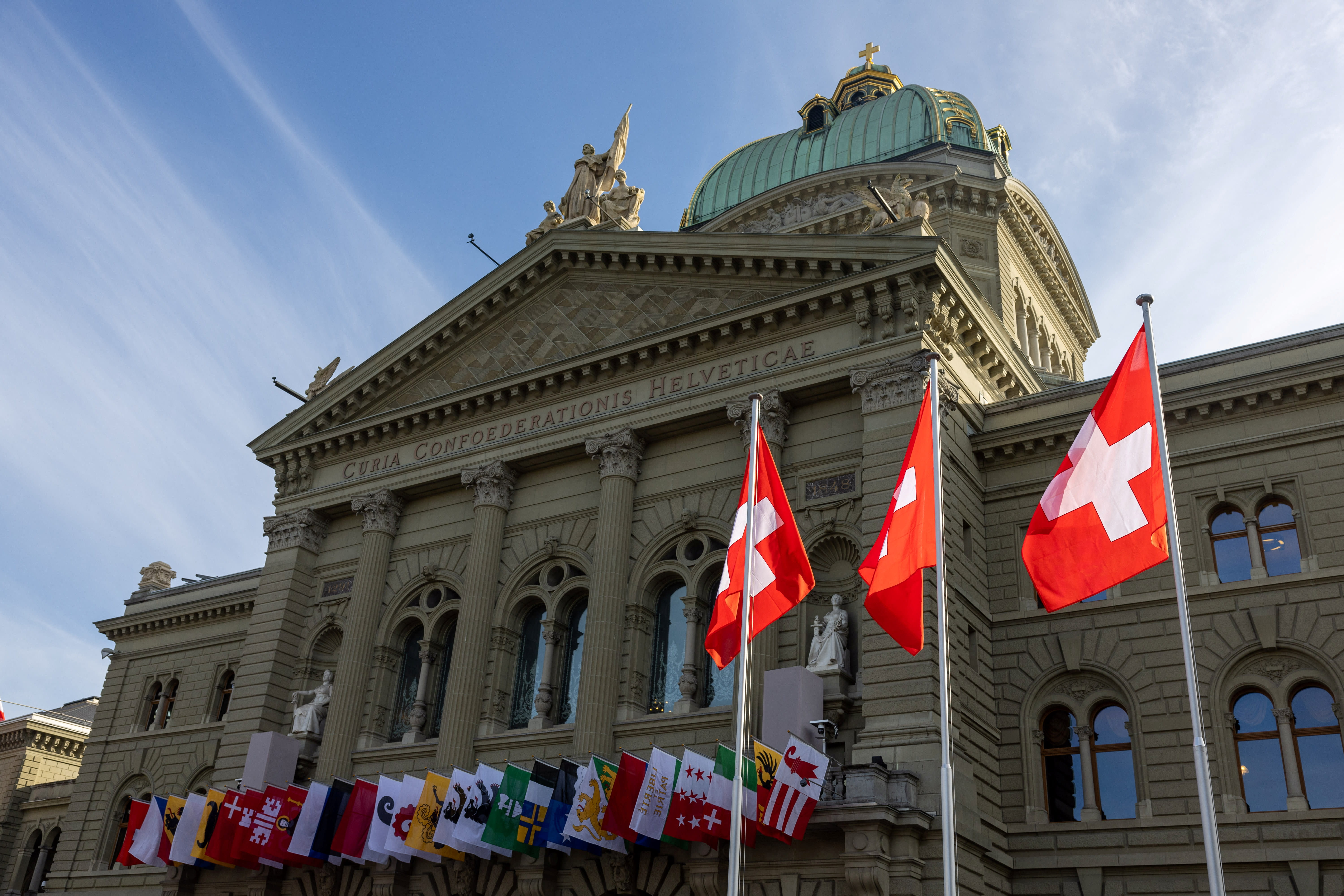 Swiss flags are seen on the Swiss Parliament building (Bundeshaus) in Bern, Switzerland, November 6, 2024. (photo credit: REUTERS/DENIS BALIBOUSE)