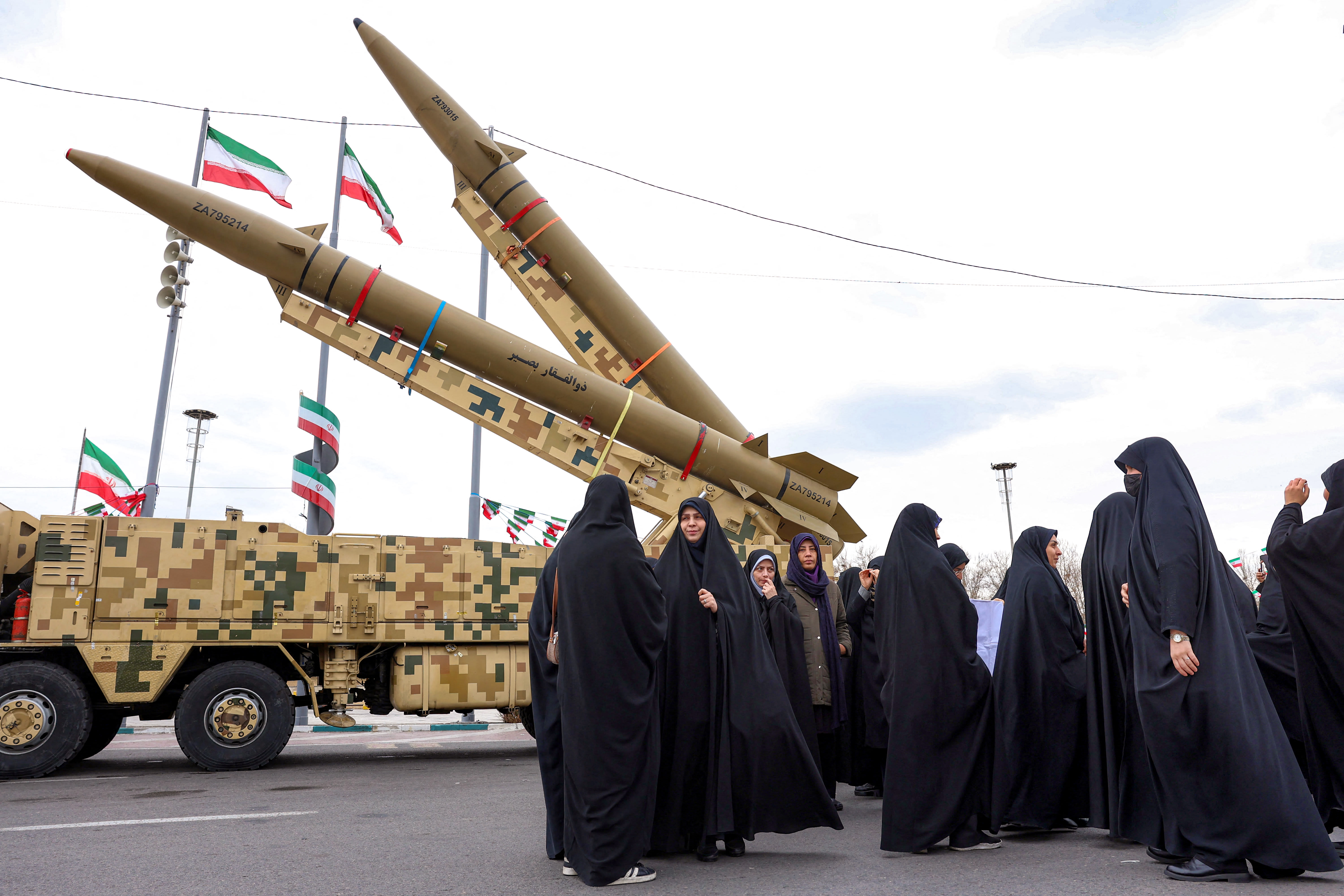 Women walk near ballistic missile launch vehicles in Tehran on February 11, 2026, during a rally marking the 47th anniversary of the 1979 Islamic revolution.  (photo credit: AFP VIA GETTY IMAGES)