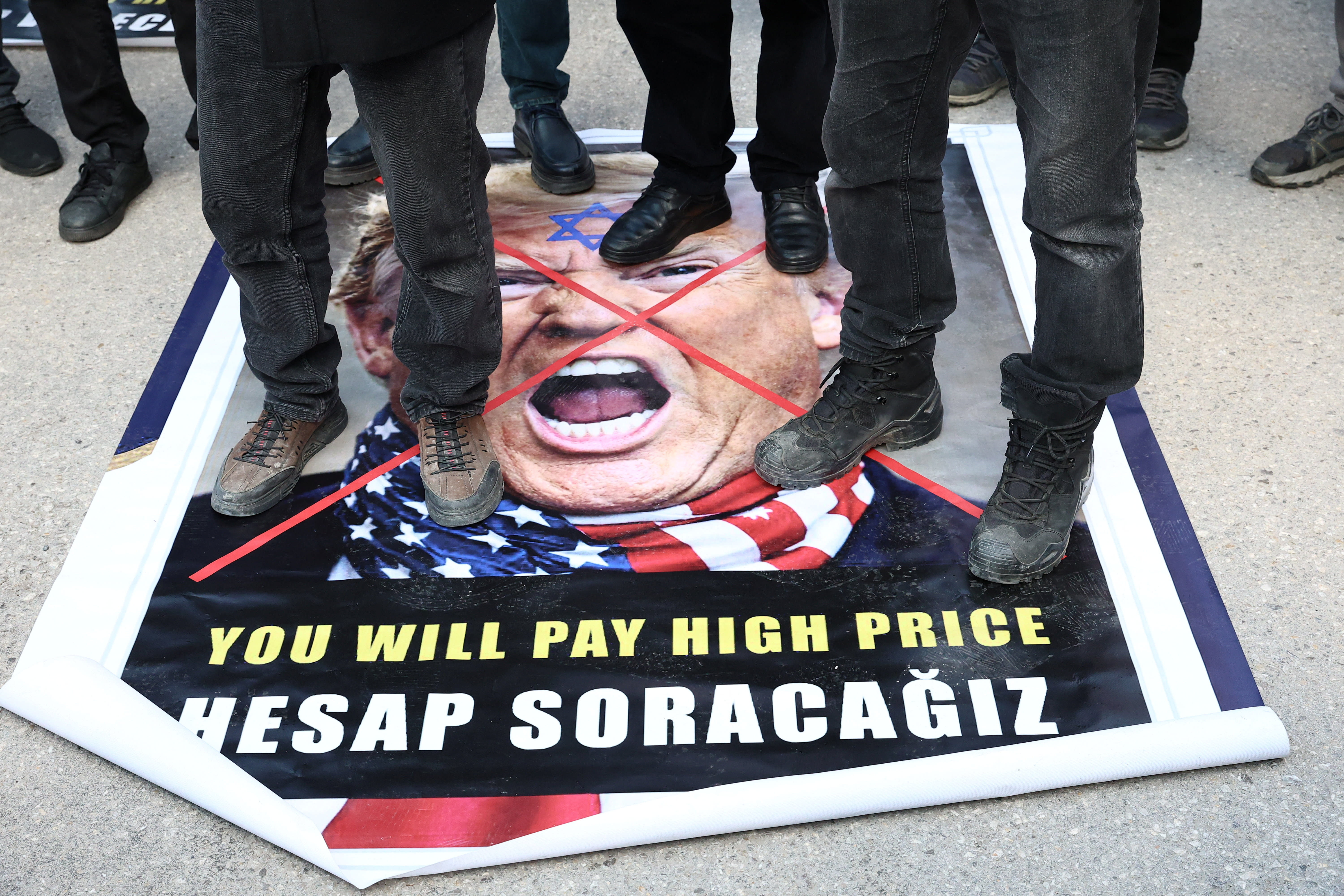 Demonstrators protesting against the attacks on Iran step on a poster of US President Donald Trump, in Turkey. (photo credit: Efekan Akyuz/Reuters)