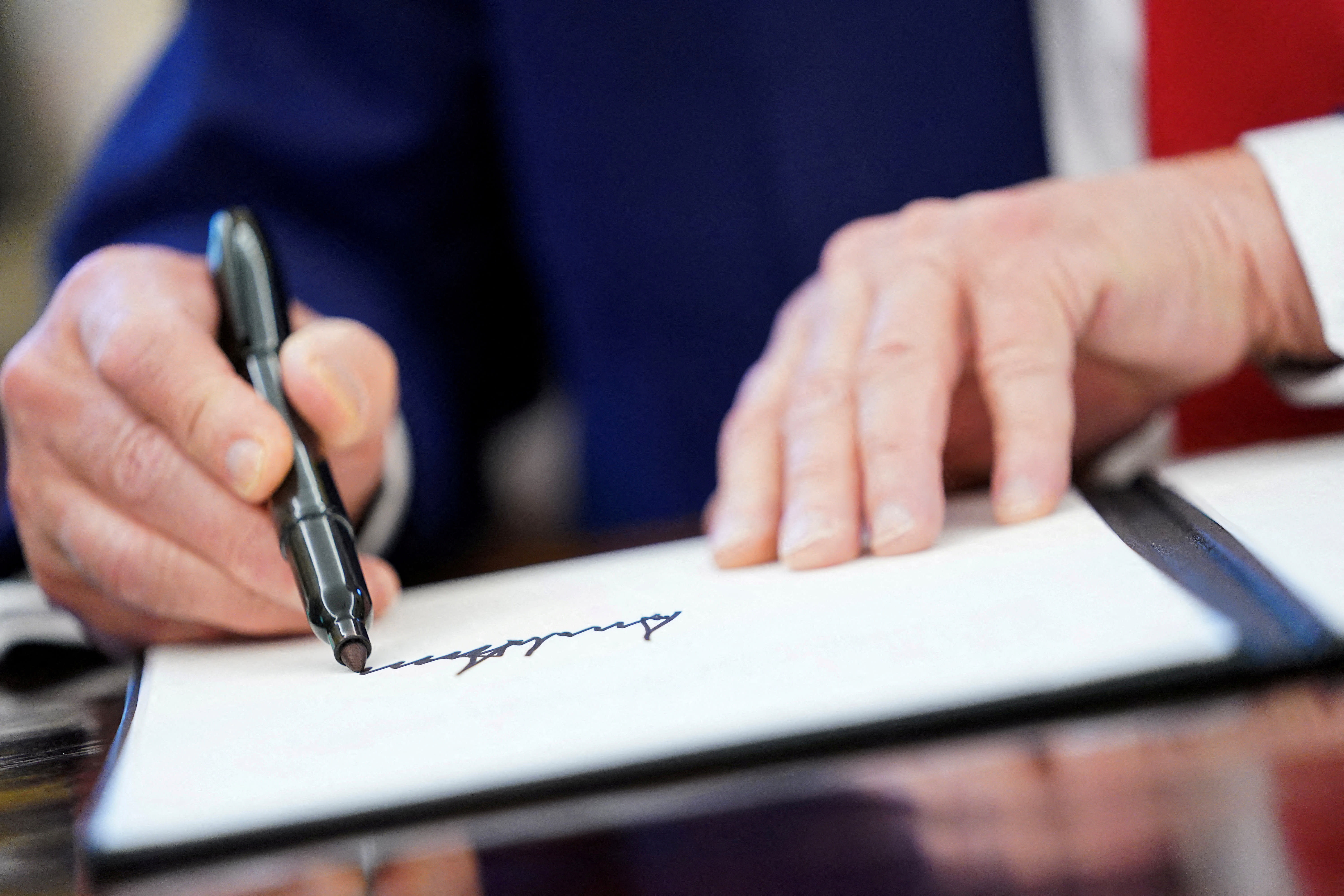 US President Donald Trump writes his signature, as he signs executive orders and proclamations in the Oval Office at the White House in Washington, DC, US, April 9, 2025. (photo credit: REUTERS/NATHAN HOWARD/FILE PHOTO)