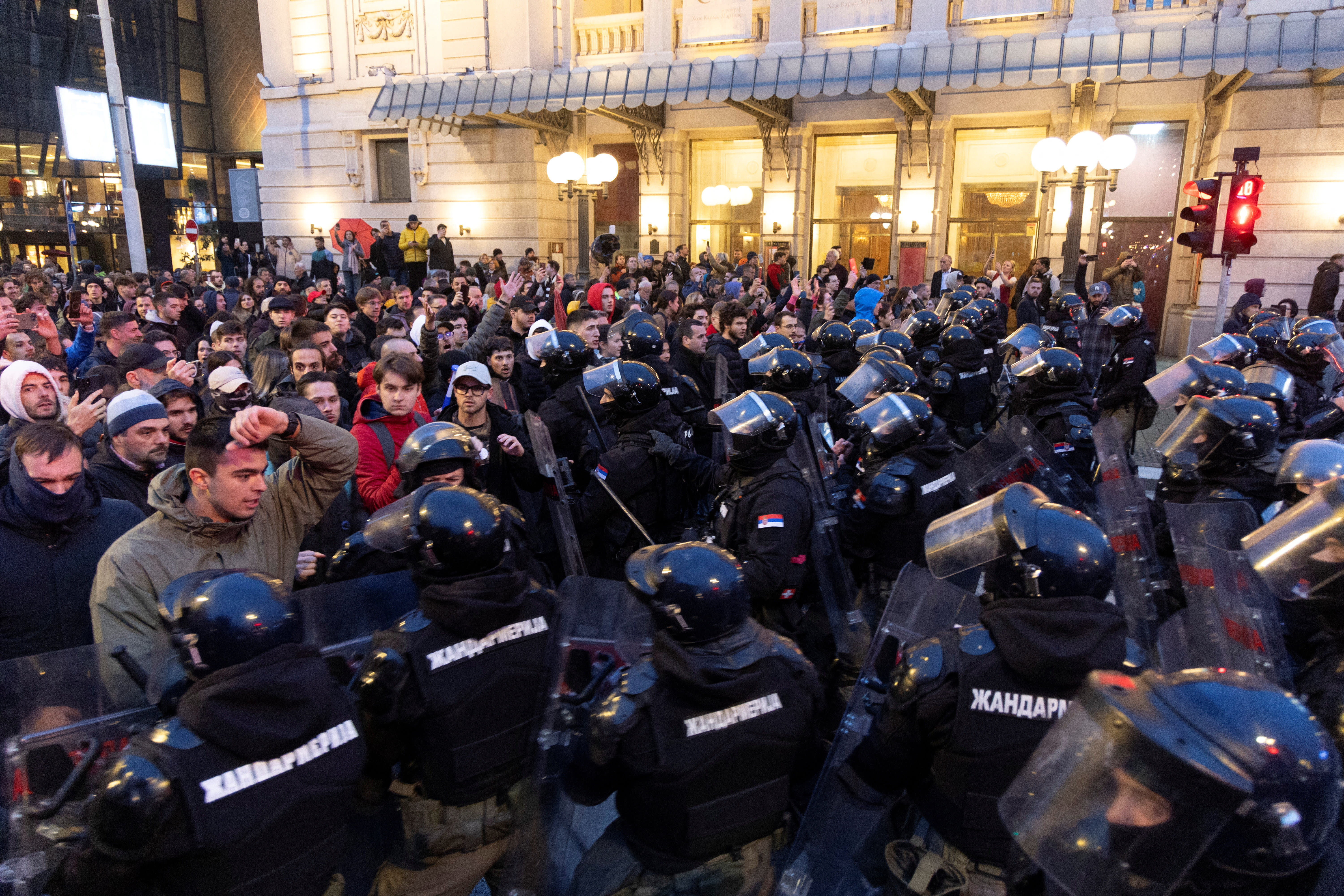 Serbian police officers stand guard as people rally to protest police search of Belgrade