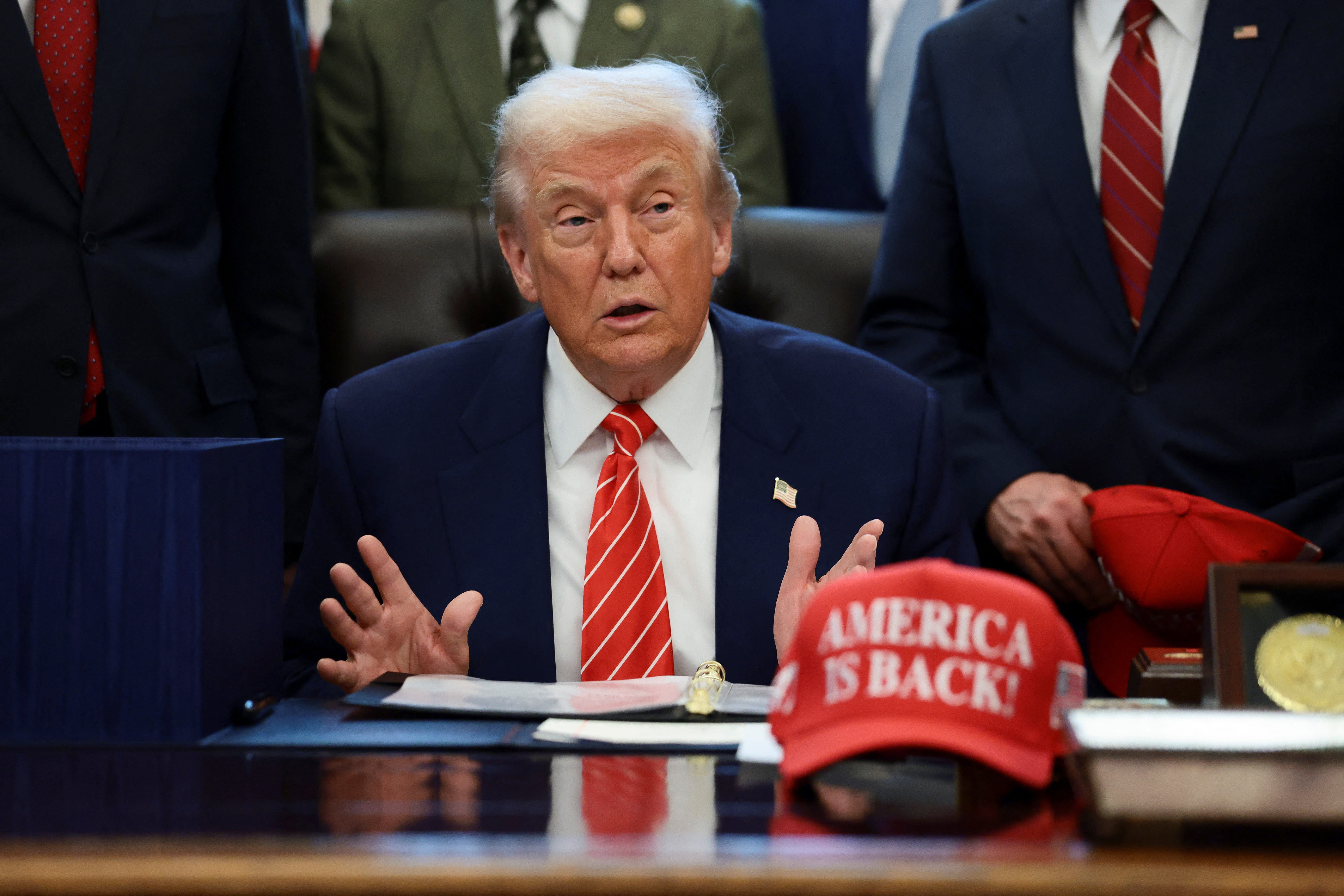 US President Donald Trump sits at his desk, behind a hat that reads "America is back" at the White House in Washington, DC, US, February 3, 2026. (photo credit: EVELYN HOCKSTEIN/REUTERS)