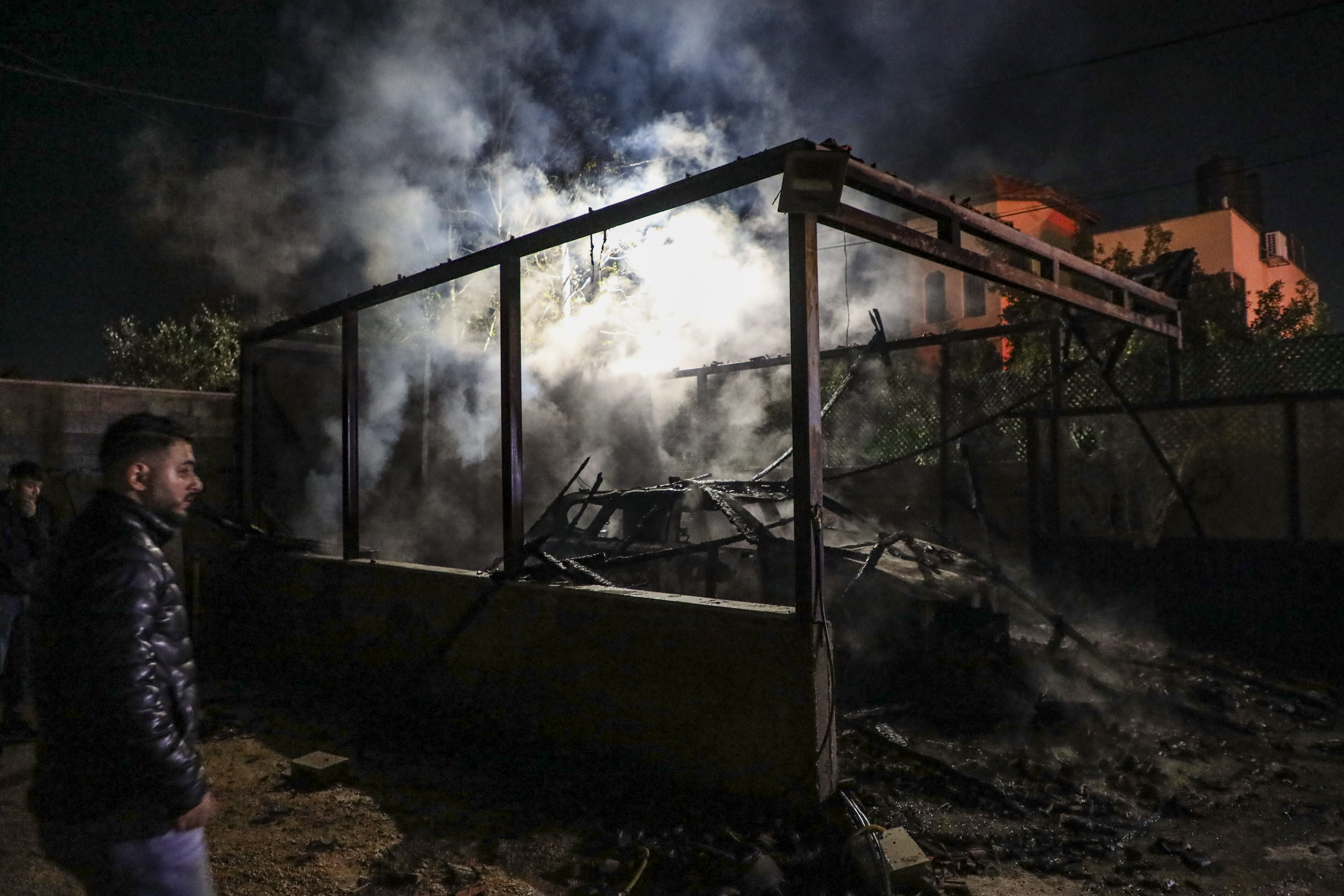Palestinians stand at the scene where vehicles and homes were set on fire following an attack by extremist Jewish settlers on the village of Deir al-Hatab, east of Nablus in the West Bank, March 22, 2026. (photo credit: NASSER ISHTAYEH/FLASH90)