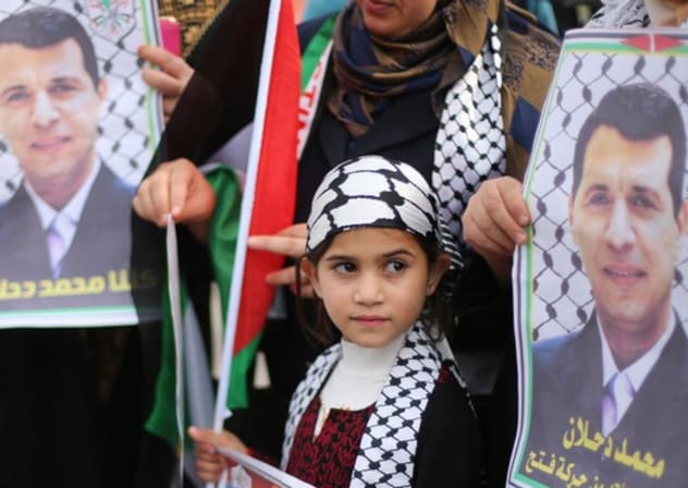 Palestinians hold posters of Mohammed Dahlan during a Gaza rally, December 18, 2014