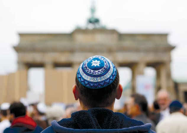 A MAN wearing a kippa waits for the start of a demonstration against antisemitism at Berlin’s Brandenburg Gate in 2014