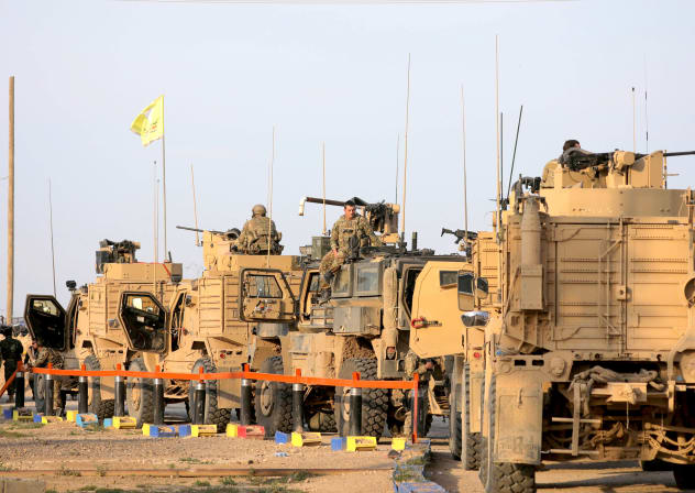 AMERICAN SOLDIERS stand near military trucks at al-Omar oil field in Deir Al Zor, Syria, on March 23. 