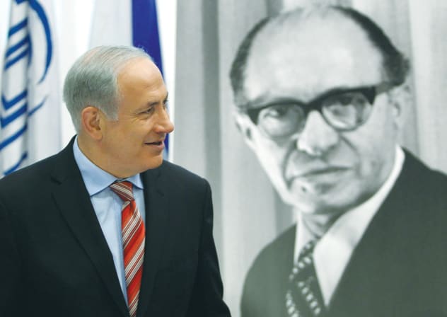  BENJAMIN NETANYAHU walks in front of a poster of Menachem Begin at the Begin Heritage Center in Jerusalem. 