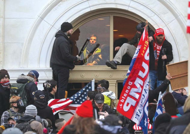  A MOB of supporters of then-US president Donald Trump climb through a window they broke, as they storm the United States Capitol Building in Washington, on January 6, 2021