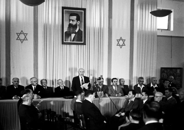  David Ben-Gurion publicly pronouncing the Declaration of the State of Israel, May 14, 1948, beneath a large portrait of Theodor Herzl, founder of modern political Zionism, in the old Tel Aviv Museum of Art building on Rothschild Street. 