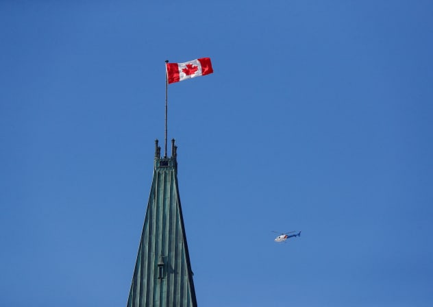  Royal Canadian Mounted Police (RCMP) helicopter flies past the Peace Tower on Parliament Hill, during the visit of U.S. President Joe Biden, in Ottawa, Ontario, Canada March 24, 2023.