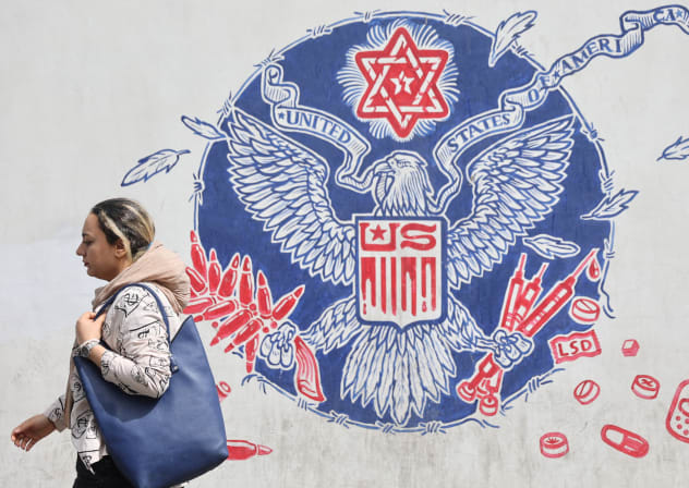  An Iranian woman walks past an anti-US mural on a street in Tehran, Iran, April 26, 2025; illustrative