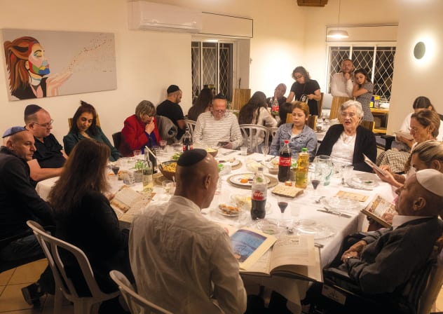   A family sit together for the Passover Seder in Ramat Gan, in 2021