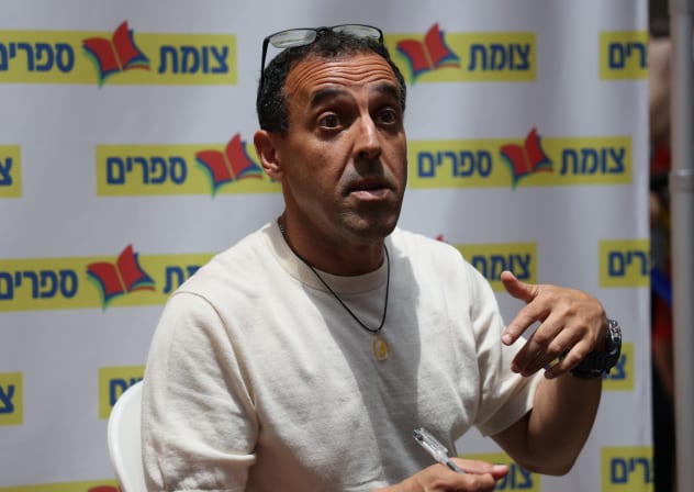 Released hostage Eli Sharabi signs his book “Hostage," during an event in Modi'in, July 2, 2025