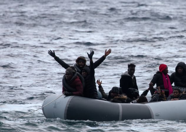 Migrants from sub-saharan African countries on a dinghy react as they are towed by a rescue boat during their effort to cross part of the Aegean Sea from Turkey to the island of Lesbos, Greece, February 29, 2020. 