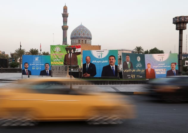 Campaign posters for parliamentary candidates are displayed near a mosque, ahead of the upcoming parliamentary elections, in Baghdad, Iraq, October 8, 2025. Picture taken with a long exposure.