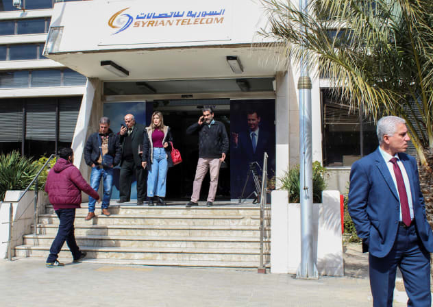 People stand in front of Syrian Telecom building in Damascus, Syria February 21, 2022. 