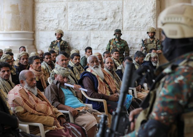 Houthi soldiers stand guard as people detained by the Houthis wait for their release in Sanaa, Yemen January 25, 2025. 