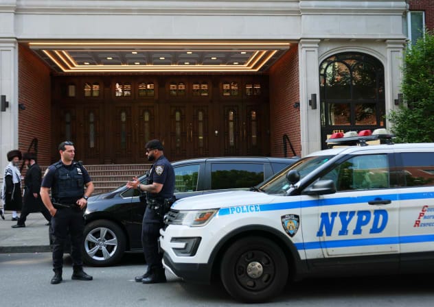 Members of the Orthodox Jewish community walk past NYPD officers as they stand guard outside of Congregation Shaarei Zion of Bobov on June 02, 2025 in the Borough Park neighborhood of the Brooklyn borough in New York City (Illustrative).  