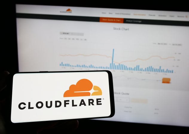 Person holding mobile phone with logo of American ICT company Cloudflare (illustrative)