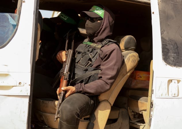 Hamas terrorist in vehicle as they go with Red Cross vehicle to area within the Yellow Line, Gaza City, November 20, 2025.