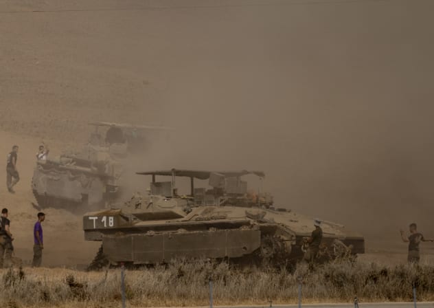 Israeli soldiers direct armored personnel carriers near the border with the Gaza Strip on October 29, 2025 in southern Israel.