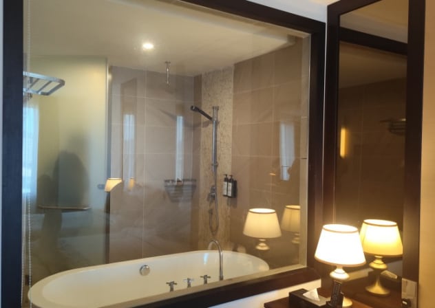 Hotel room with glass bathroom.
