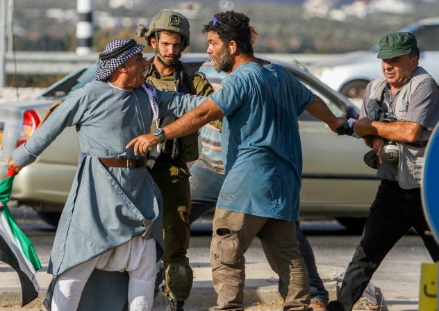 Palestinian protesters confront a jewish man during a protest against Israeli settlements, near Qalqilya, in the West Bank, on August 12, 2022. 