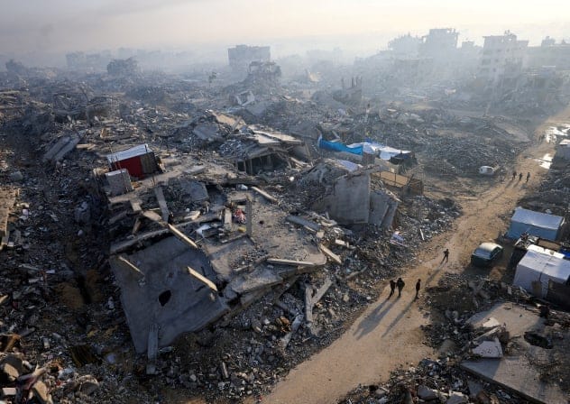  FILE PHOTO: Palestinians walk past the rubble of destroyed buildings, amid a ceasefire between Israel and Hamas, in Gaza City, November 19, 2025. 