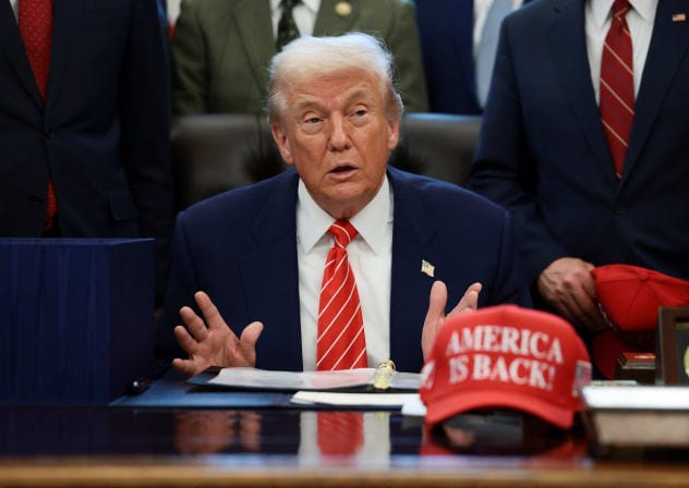 US President Donald Trump sits at his desk, behind a hat that reads "America is back" at the White House in Washington, DC, US, February 3, 2026.