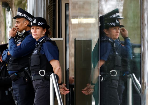 Police officers stand outside New Scotland Yard, the headquarters of the Metropolitan Police, in London, Britain March 21, 2023. 
