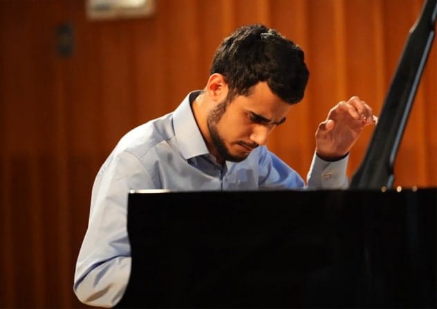 Pianist Ido Shalom takes his seat at the keyboard