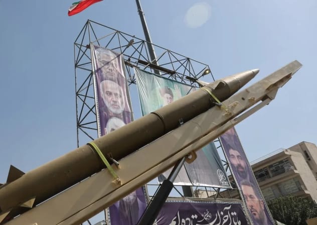 Un sistema de misiles iraní se exhibe junto a una pancarta con una imagen del líder supremo de Irán, el ayatolá Alí Jamenei, durante la Semana de la Defensa Iraní, en una calle de Teherán, Irán