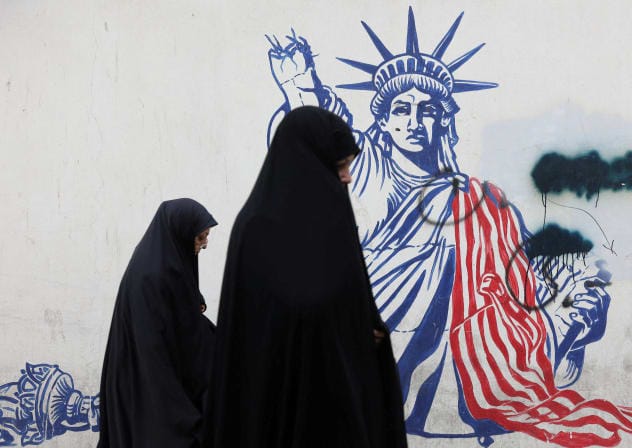 Women walk past an anti-US mural on a street in Tehran, Iran, February 5, 2026