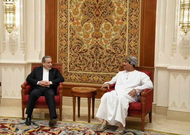 Iranian Foreign Minister Abbas Araghchi (L) talks with an Omani official in Muscat ahead of talks with the US, February 6, 2026.
