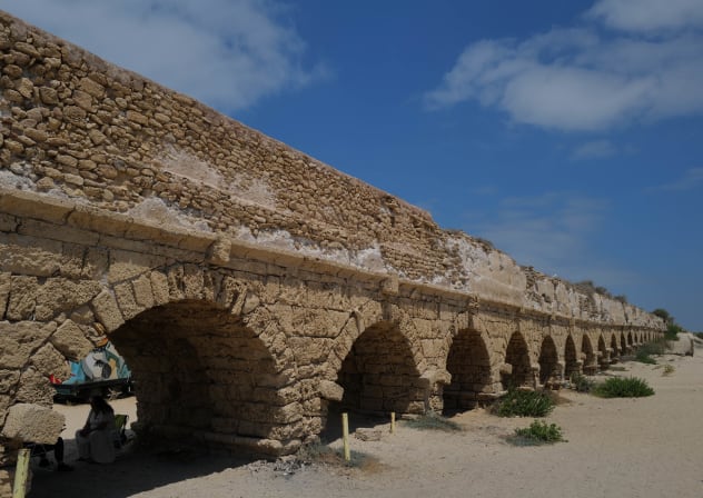 Israelis and tourists enjoy the beach near the 2,000-year-old Caesarea aqueduct, in Caesarea on August 21, 2023.