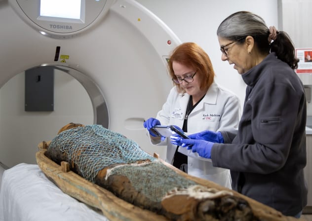 Summer Decker, PHD, (left) 3D Imaging Lead for Keck Medicine of USC, and Diane Perlov, PHD, (right), Senior Vice President for special projects at the California Science Center, examine ancient Egyptian mummy Nes-Min before he is scanned, February 6, 2026.