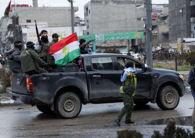 Members of the Kurdish Internal Security Forces ride in a car, while vehicles of the internal security forces of the Syrian government arrive in the city of Qamishli, Syria, February 3, 2026