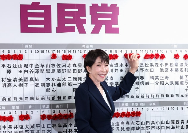 Japan's Prime Minister Sanae Takaichi, leader of the ruling Liberal Democratic Party (LDP), places a red paper rose on the name of an elected candidate at the LDP headquarters on general election day in Tokyo, Japan, February 8, 2026.